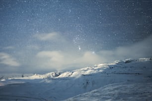 a mountain covered in snow under a night sky