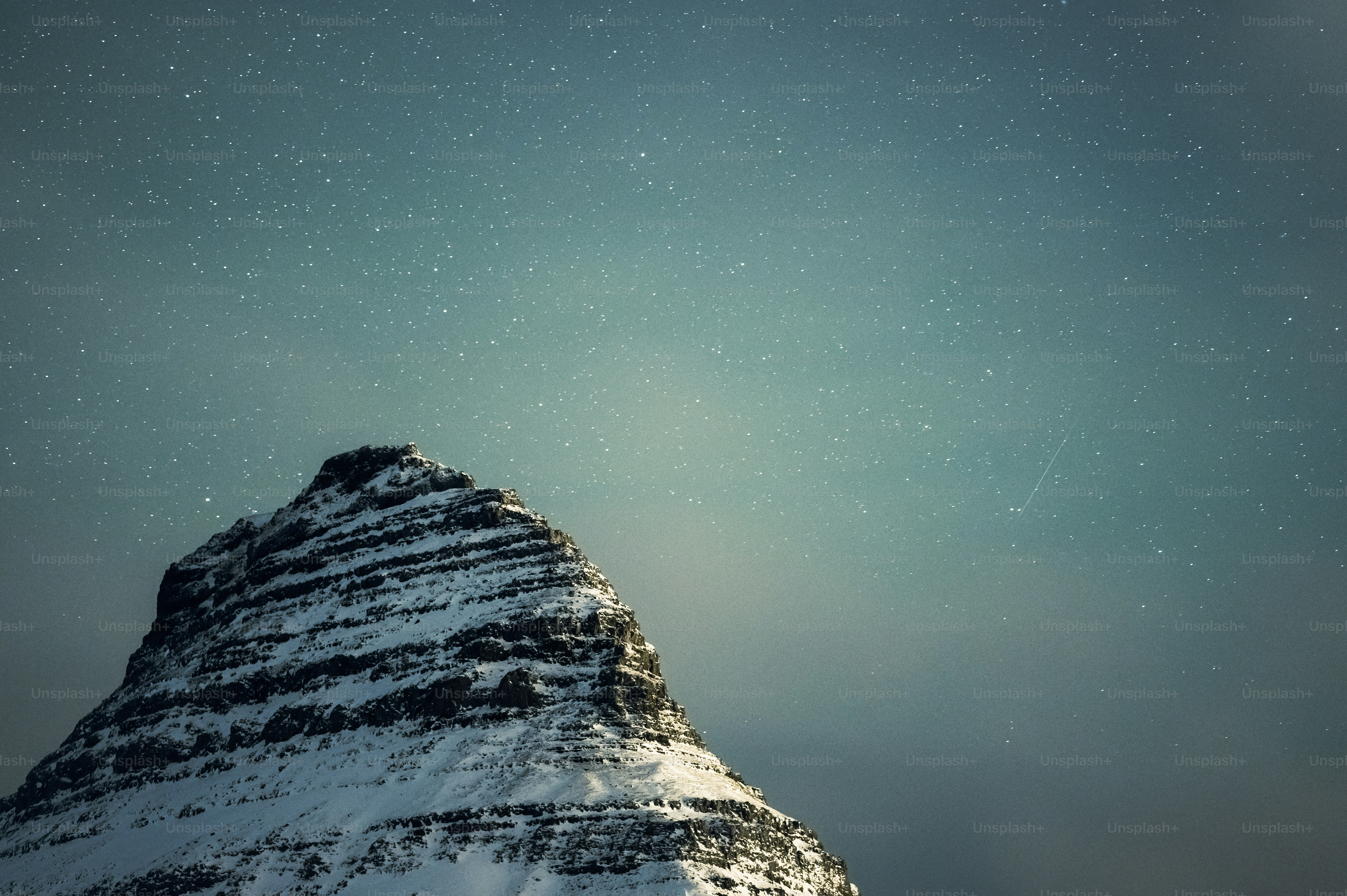 A mountain covered in snow under a blue sky photo – Winter Image on ...