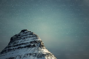 una montaña cubierta de nieve bajo un cielo lleno de estrellas