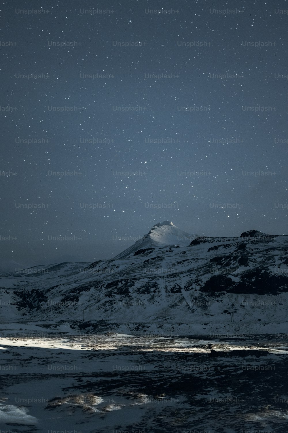 Une montagne enneigée sous un ciel nocturne