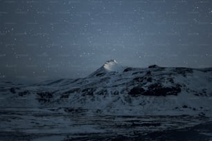 Una montaña cubierta de nieve bajo un cielo nocturno