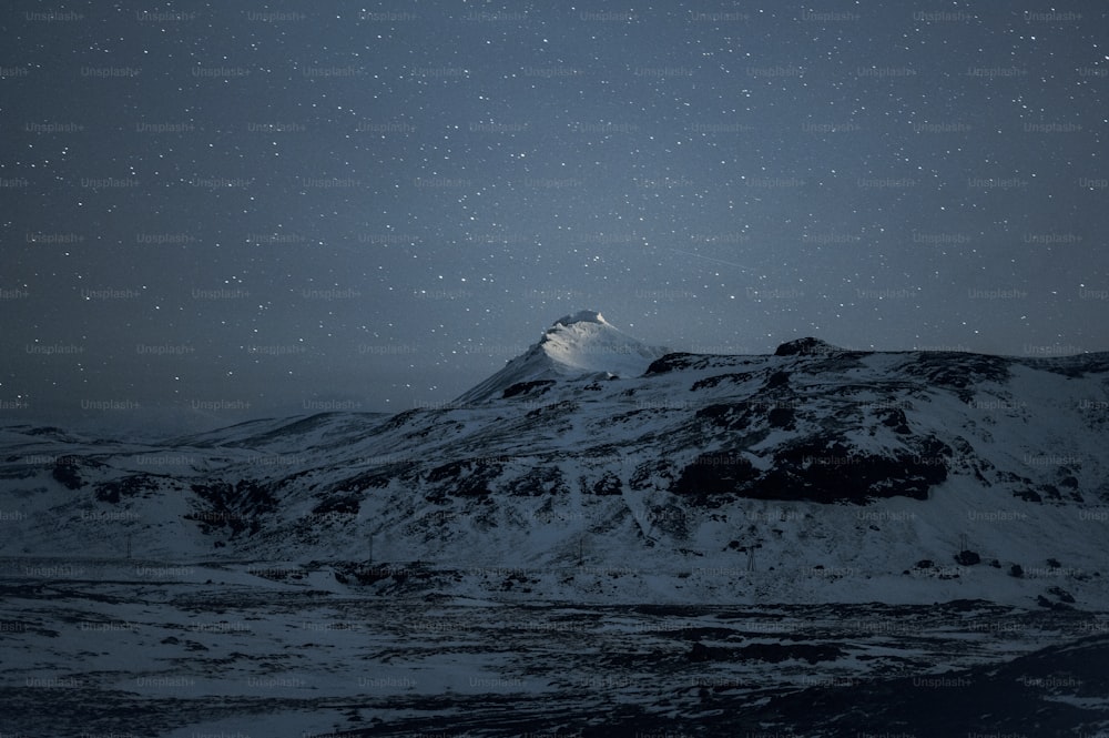 Une montagne couverte de neige sous un ciel nocturne