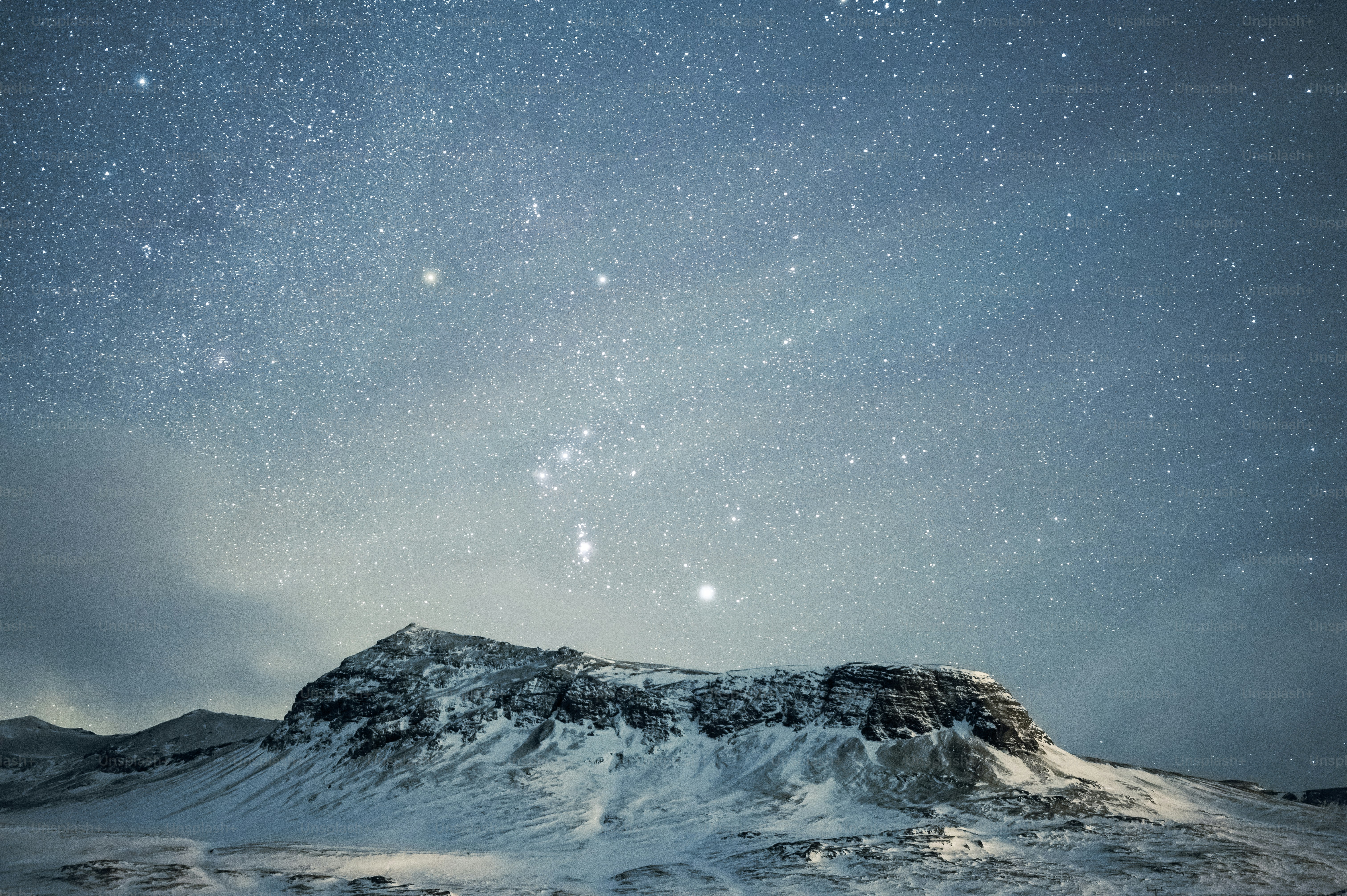a mountain covered in snow under a night sky