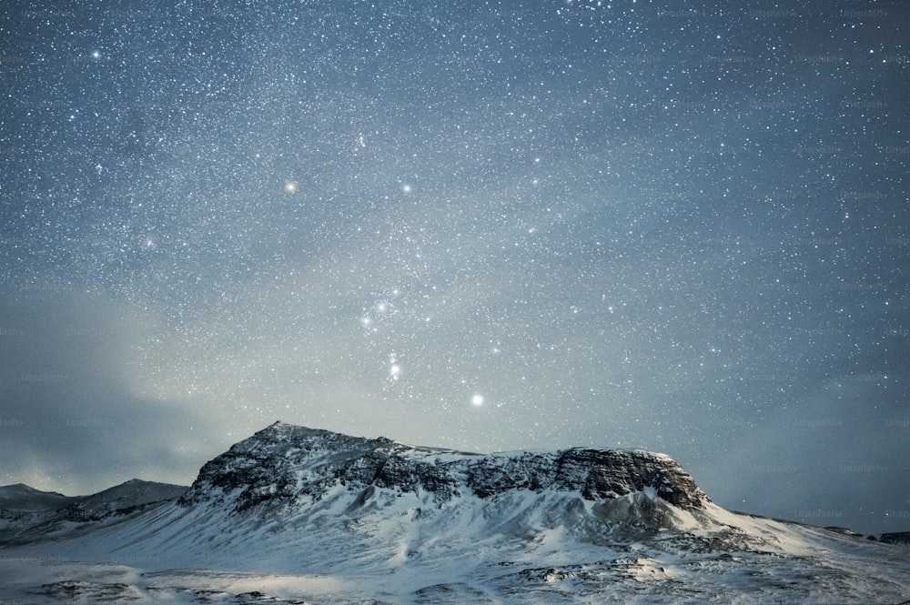 Una montagna coperta di neve sotto un cielo notturno