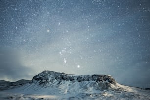 a mountain covered in snow under a night sky