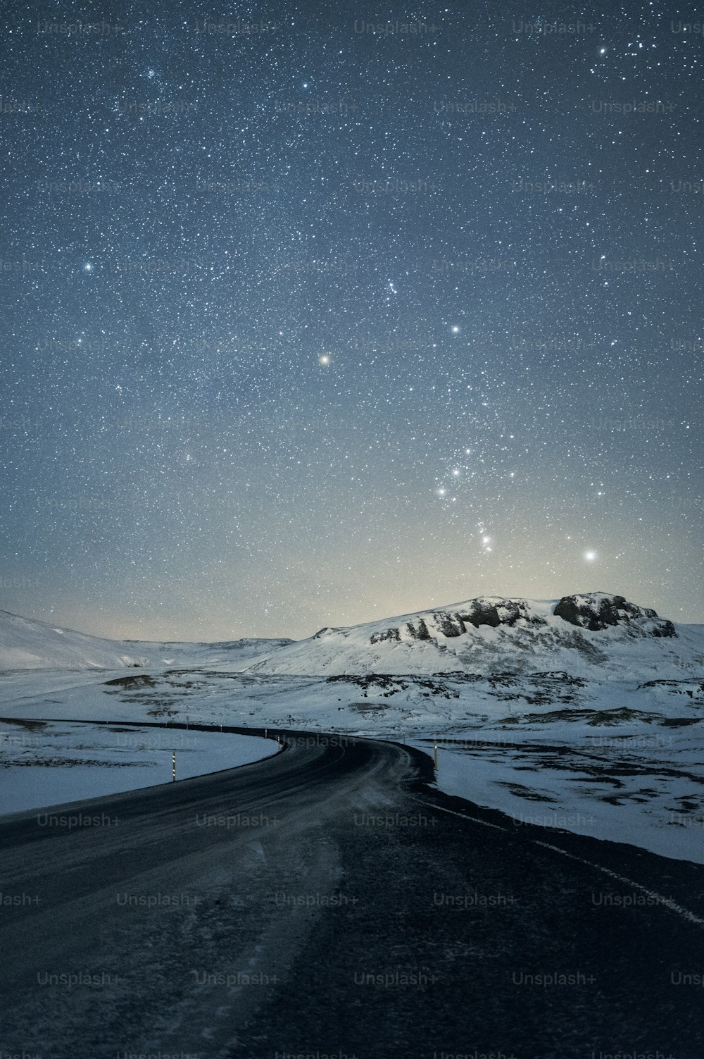 밤하늘은 눈 덮��인 산 위의 별들로 가득 차 있습니다.