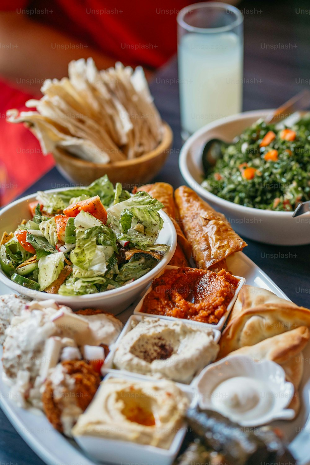 a white plate topped with lots of food next to a glass of milk