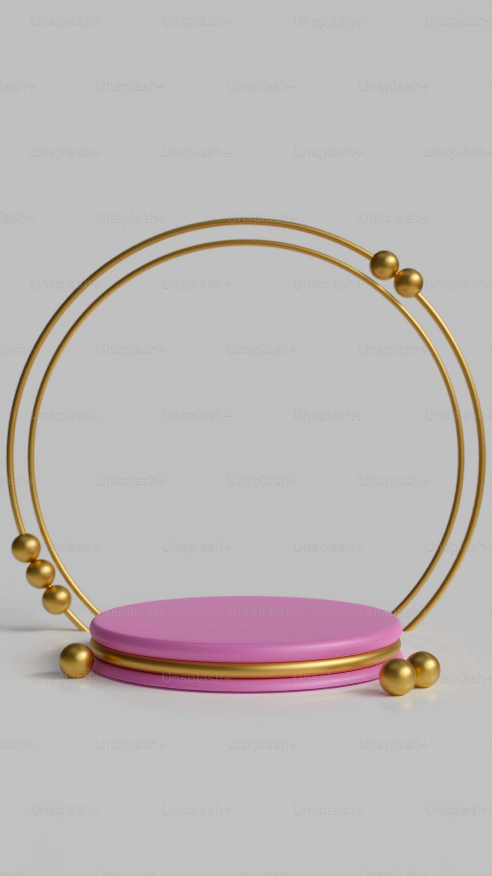 um objeto rosa com bolas de ouro em torno dele