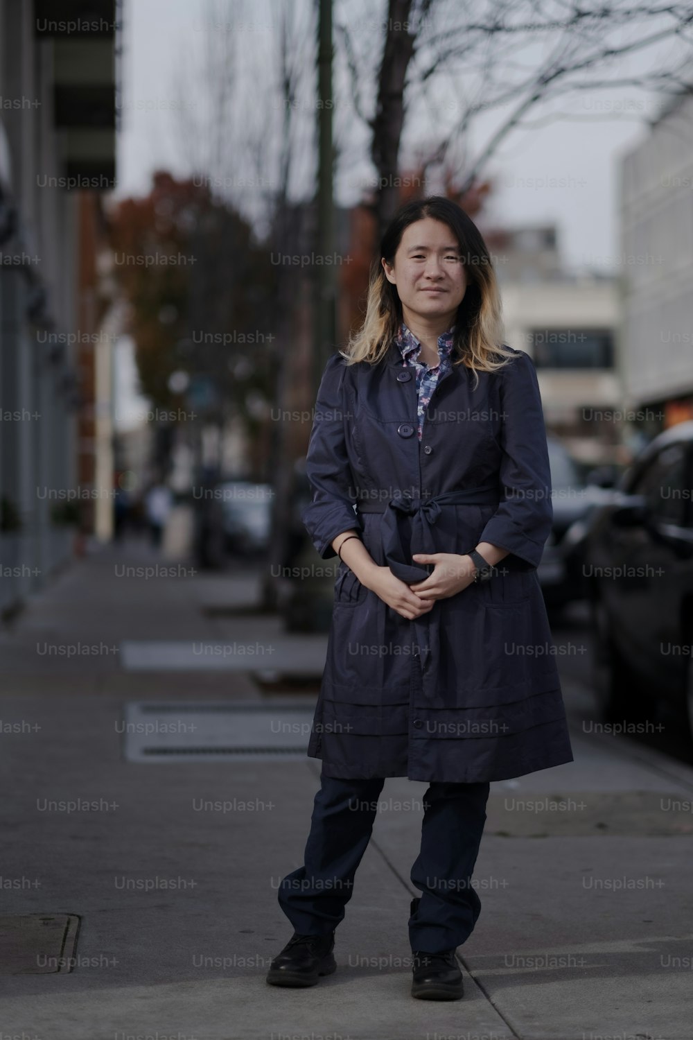 a woman standing on a sidewalk in front of a building