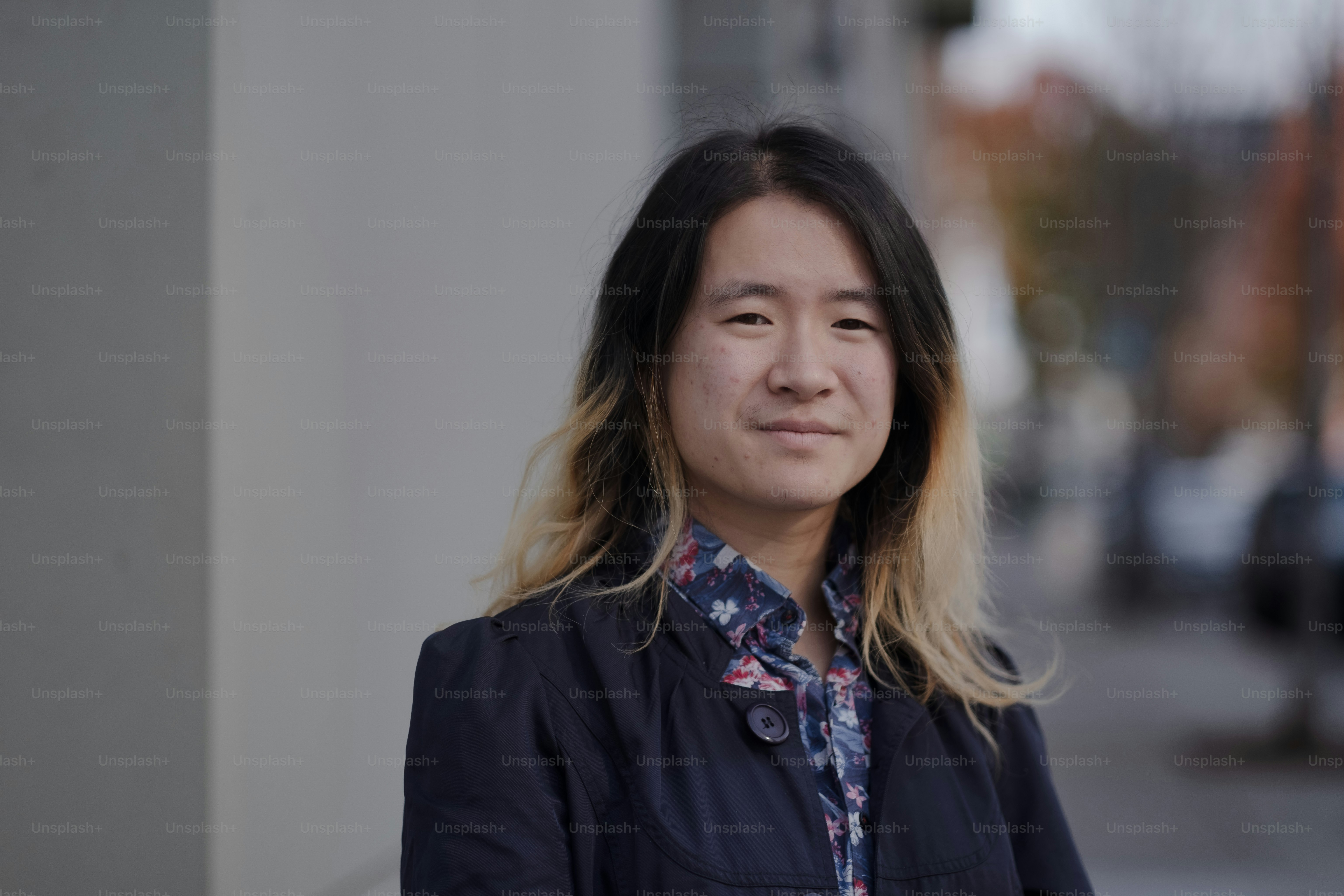 Une femme aux cheveux longs debout devant un immeuble