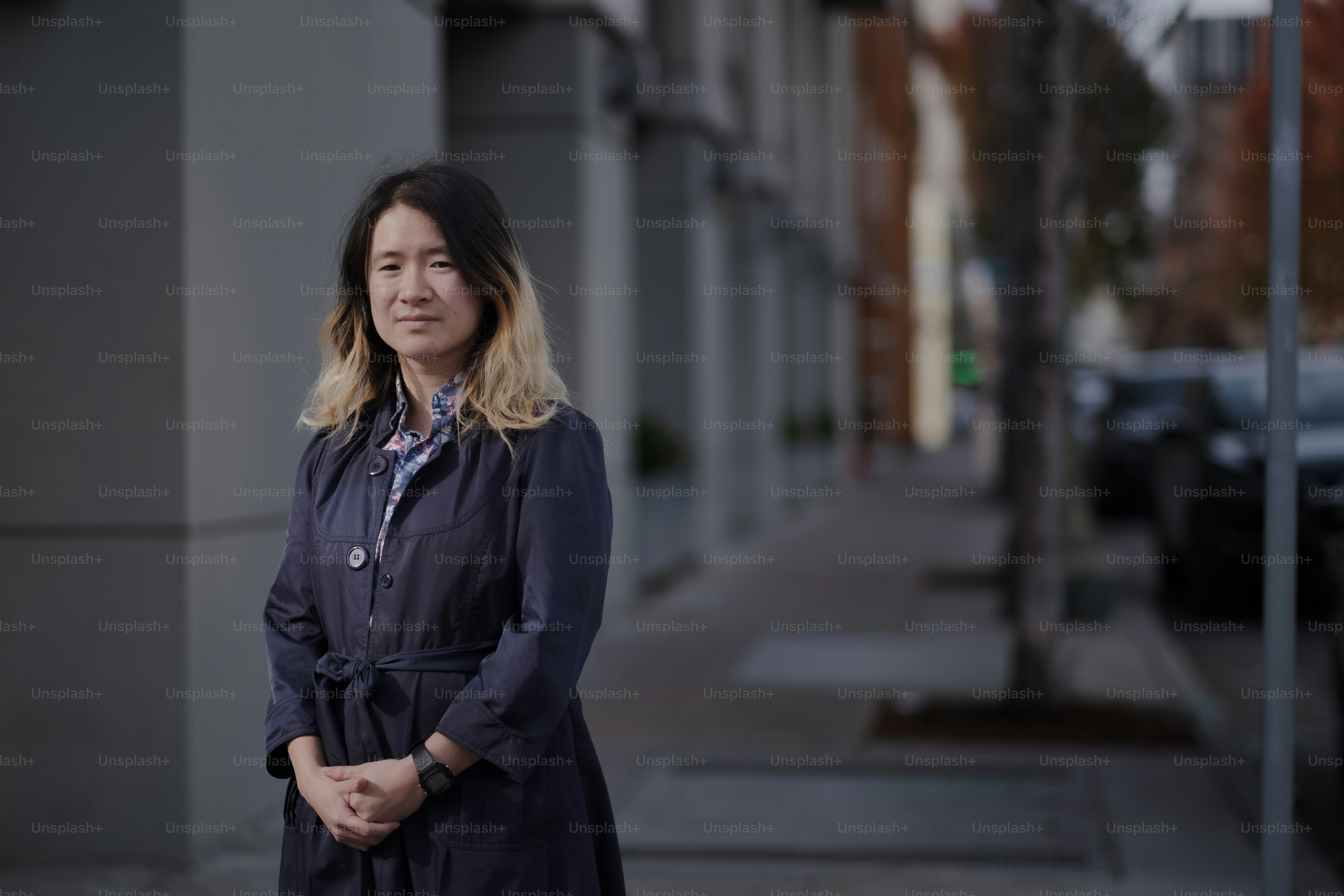 A woman standing on a sidewalk in front of a building photo – Human ...