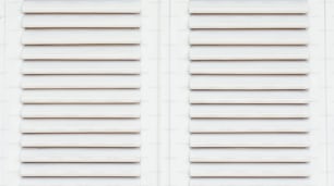 a close up of a window with white shutters