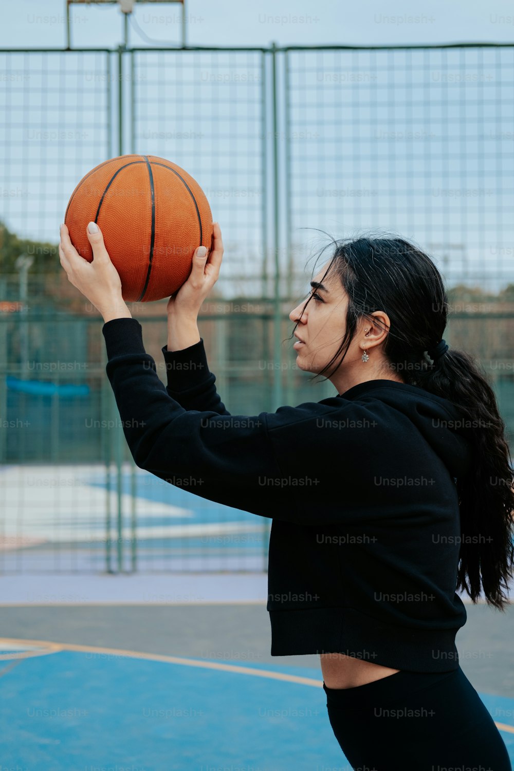Eine Frau, die einen Basketball auf einem Basketballplatz hält