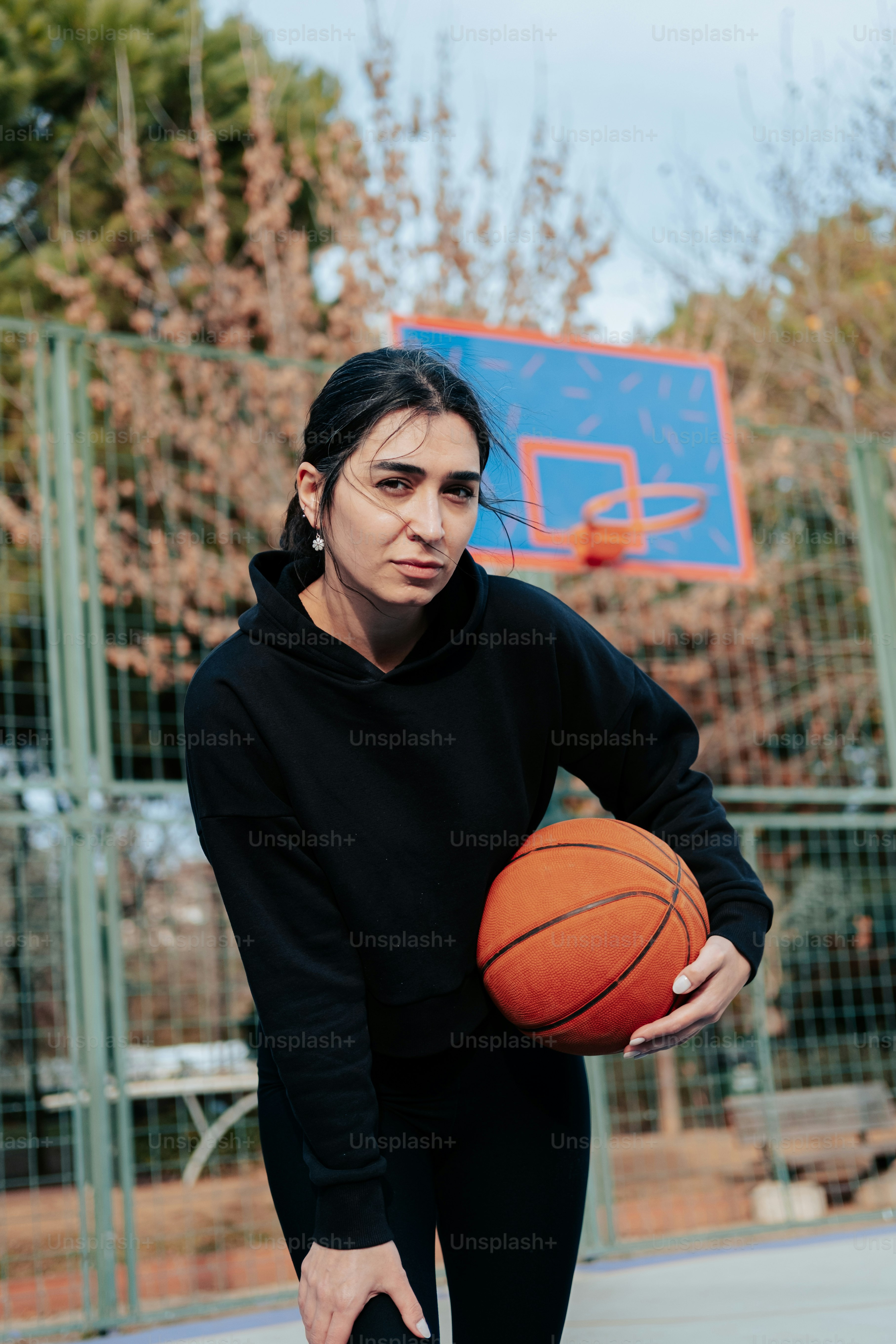 Eine Frau, die einen Basketball auf einem Basketballplatz hält