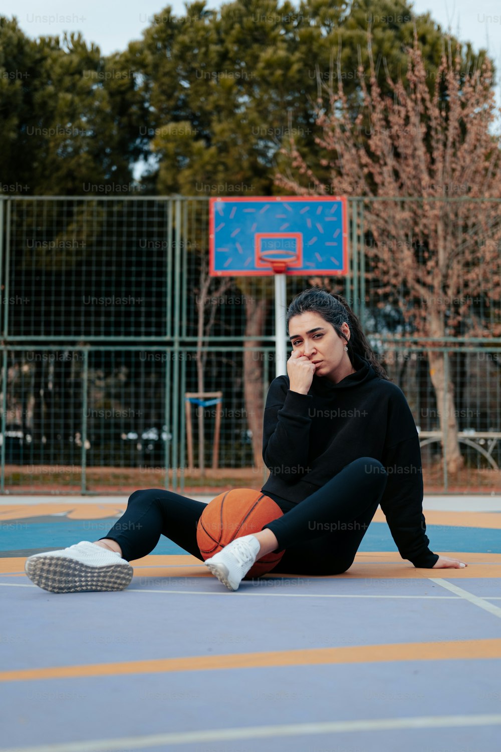 バスケットボールを手に地面に座っている女性