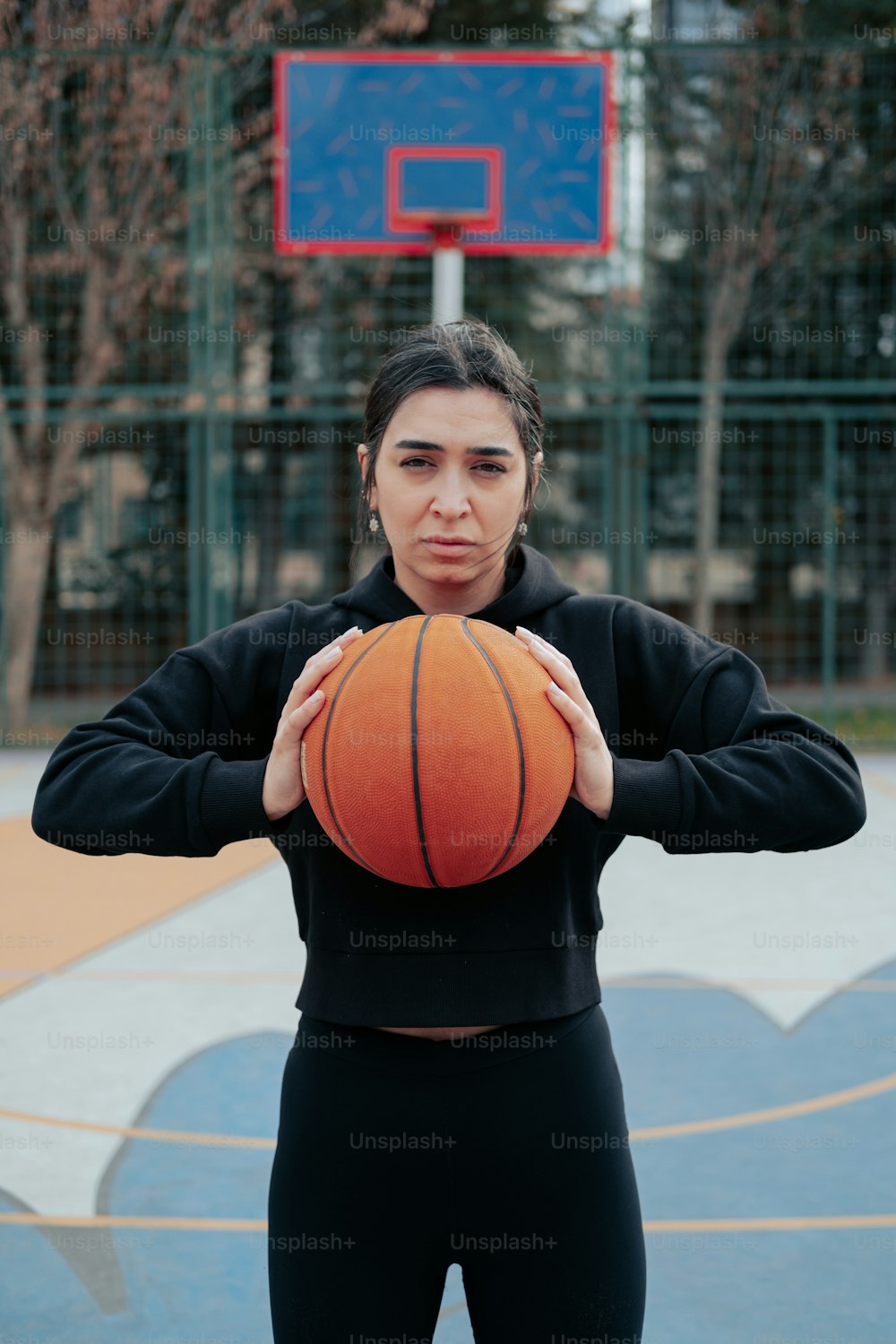 a woman holding a basketball in front of her face