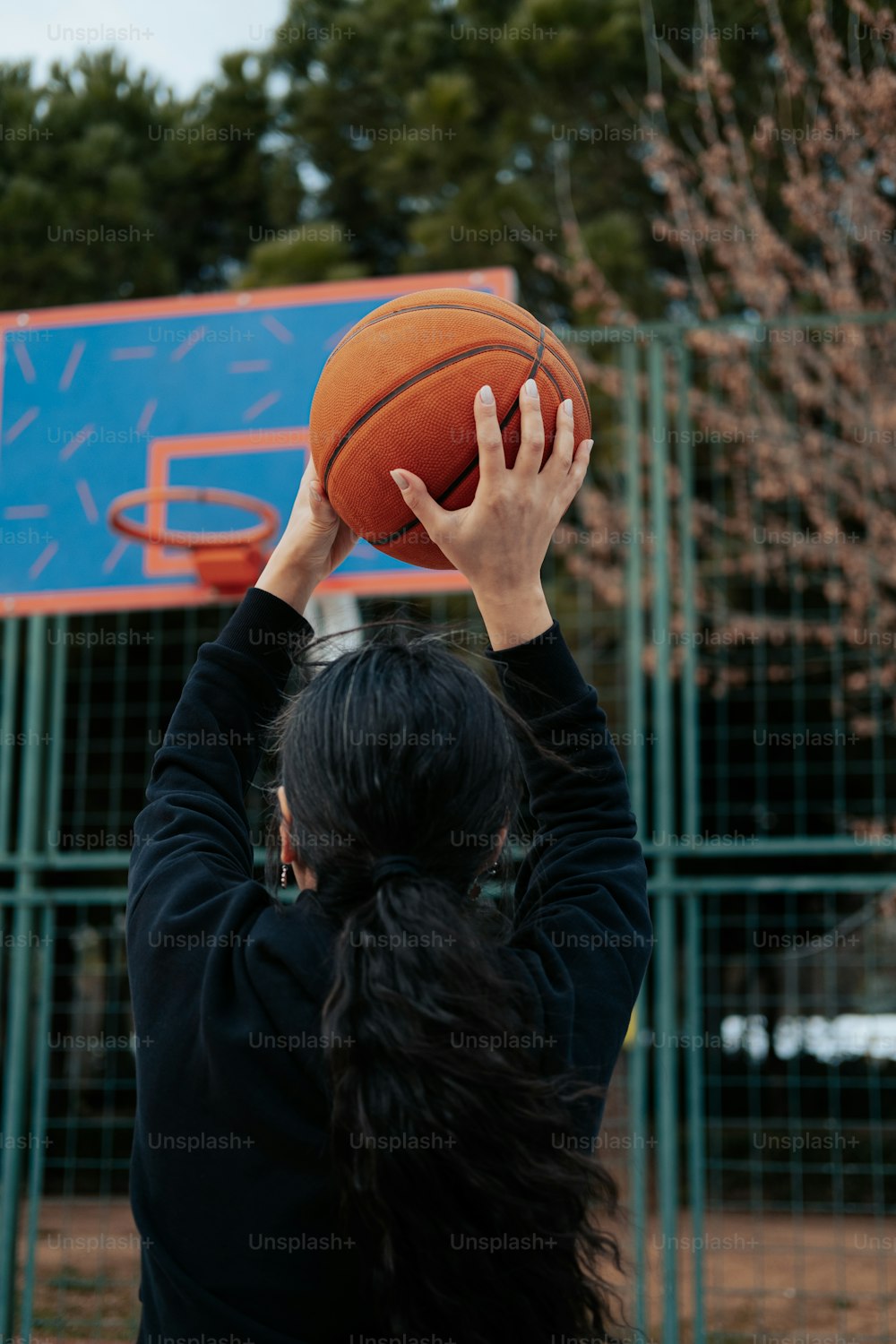 a woman holding a basketball up in the air