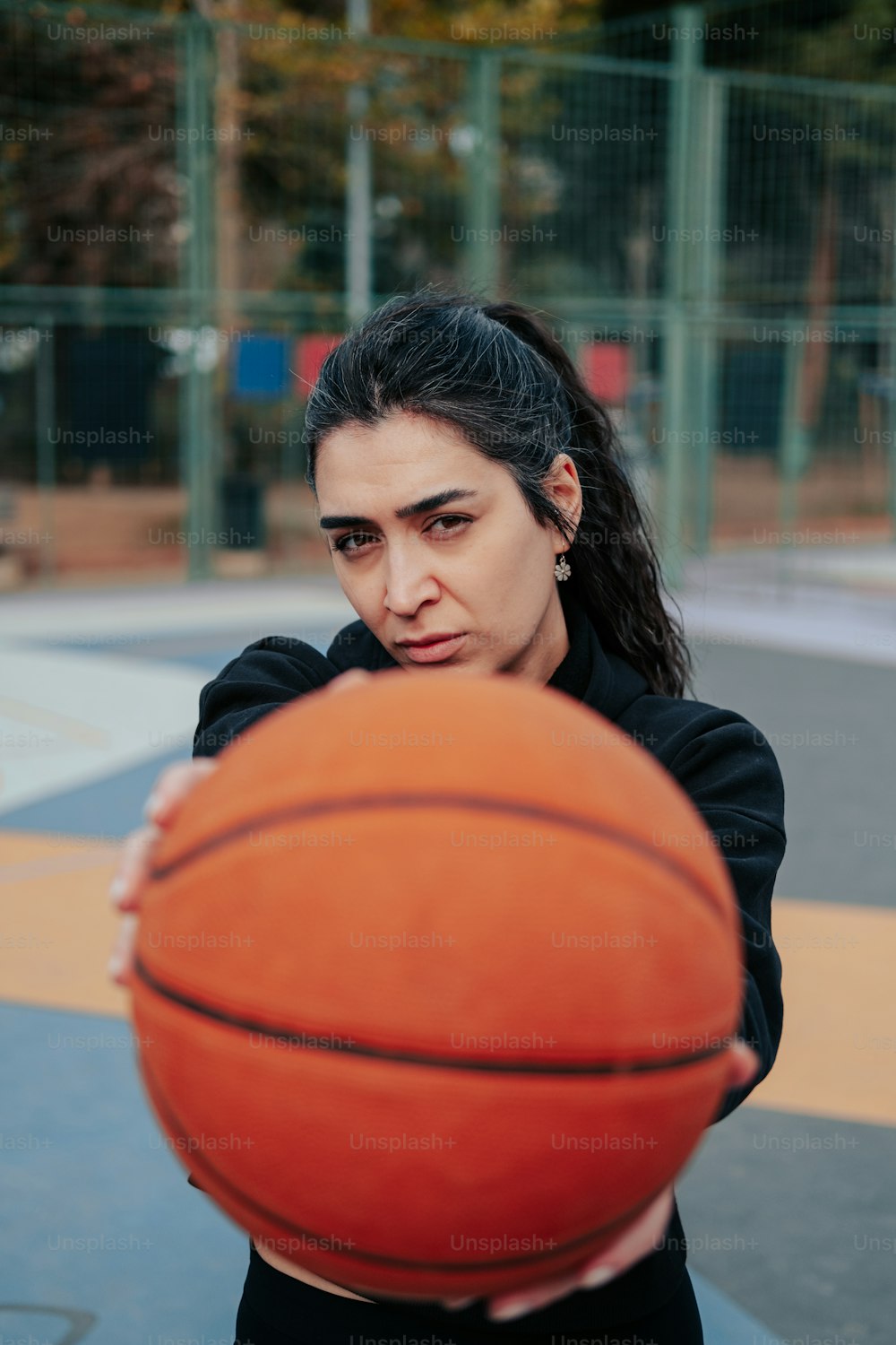 Eine Frau, die einen Basketball auf einem Basketballplatz hält