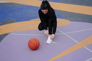 Eine Frau, die einen Schuh auf einem Basketballplatz bindet
