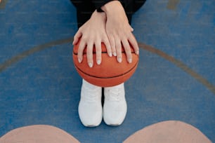 um close up de uma pessoa segurando uma bola de basquete