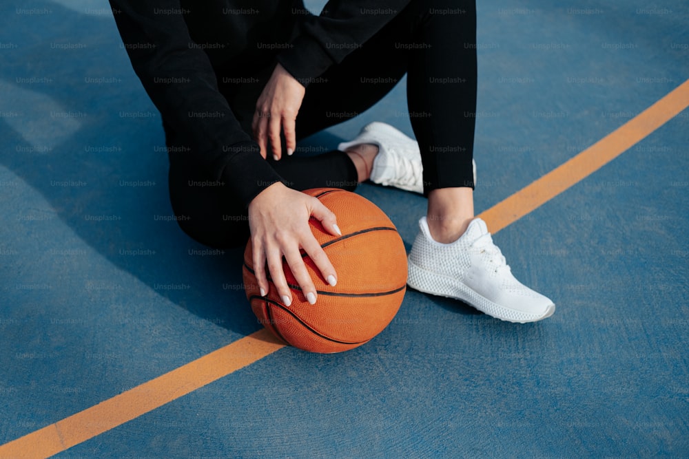 a person sitting on the ground with a basketball