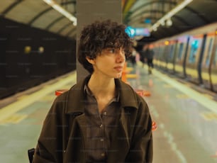 a young man standing in front of a subway train