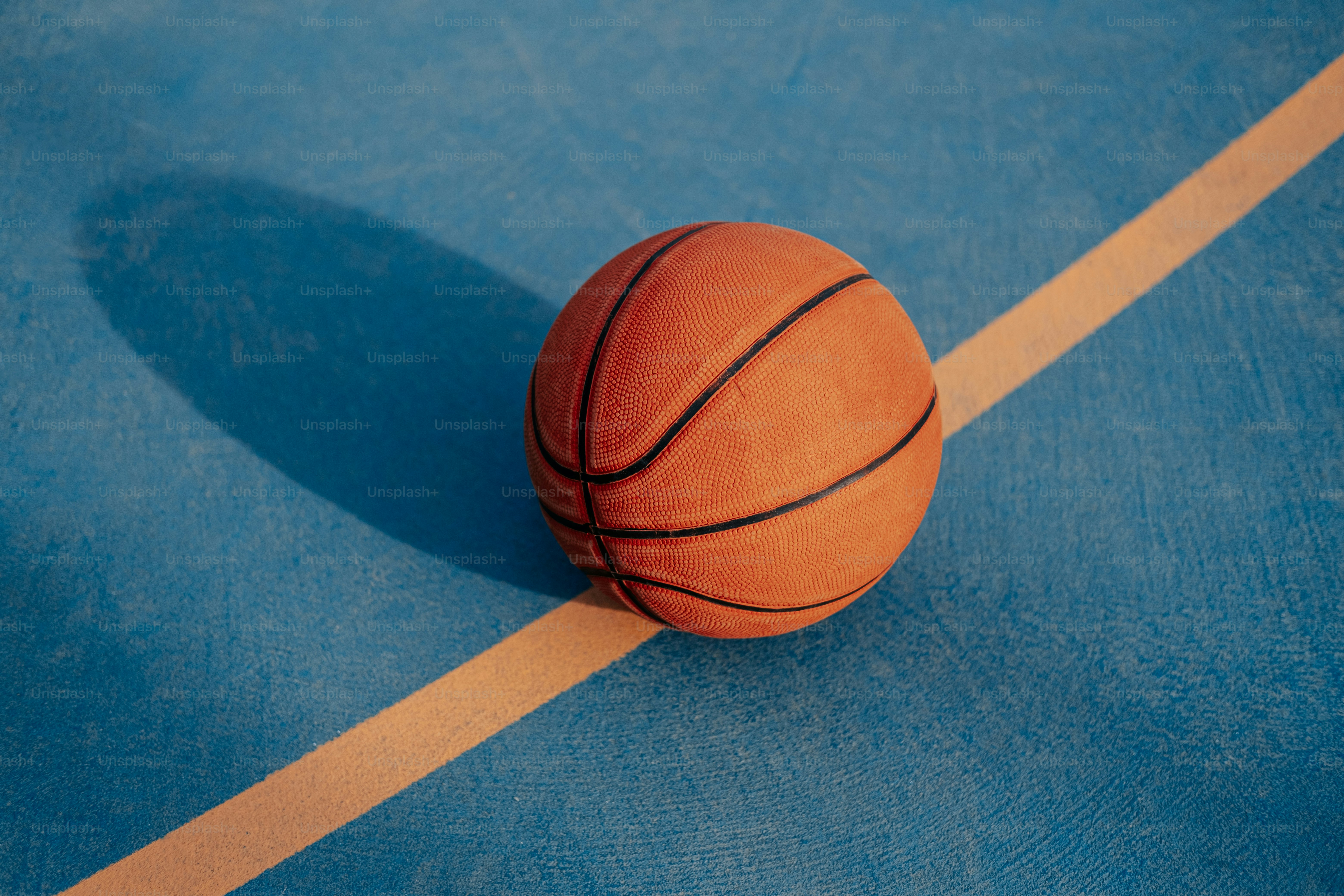 a basketball sitting on top of a blue court