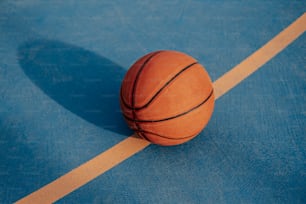 Una pelota de baloncesto sentada encima de una cancha azul