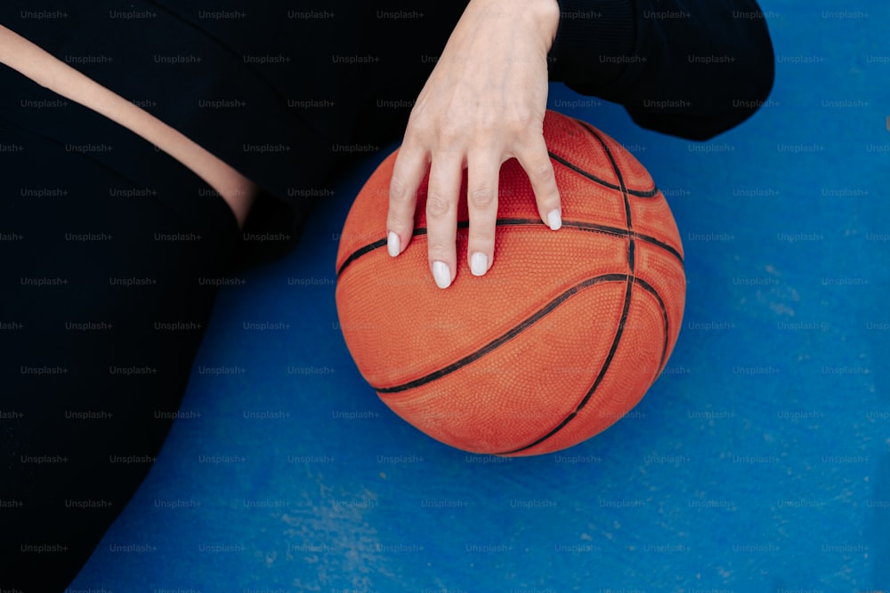 a person with their hand on a basketball