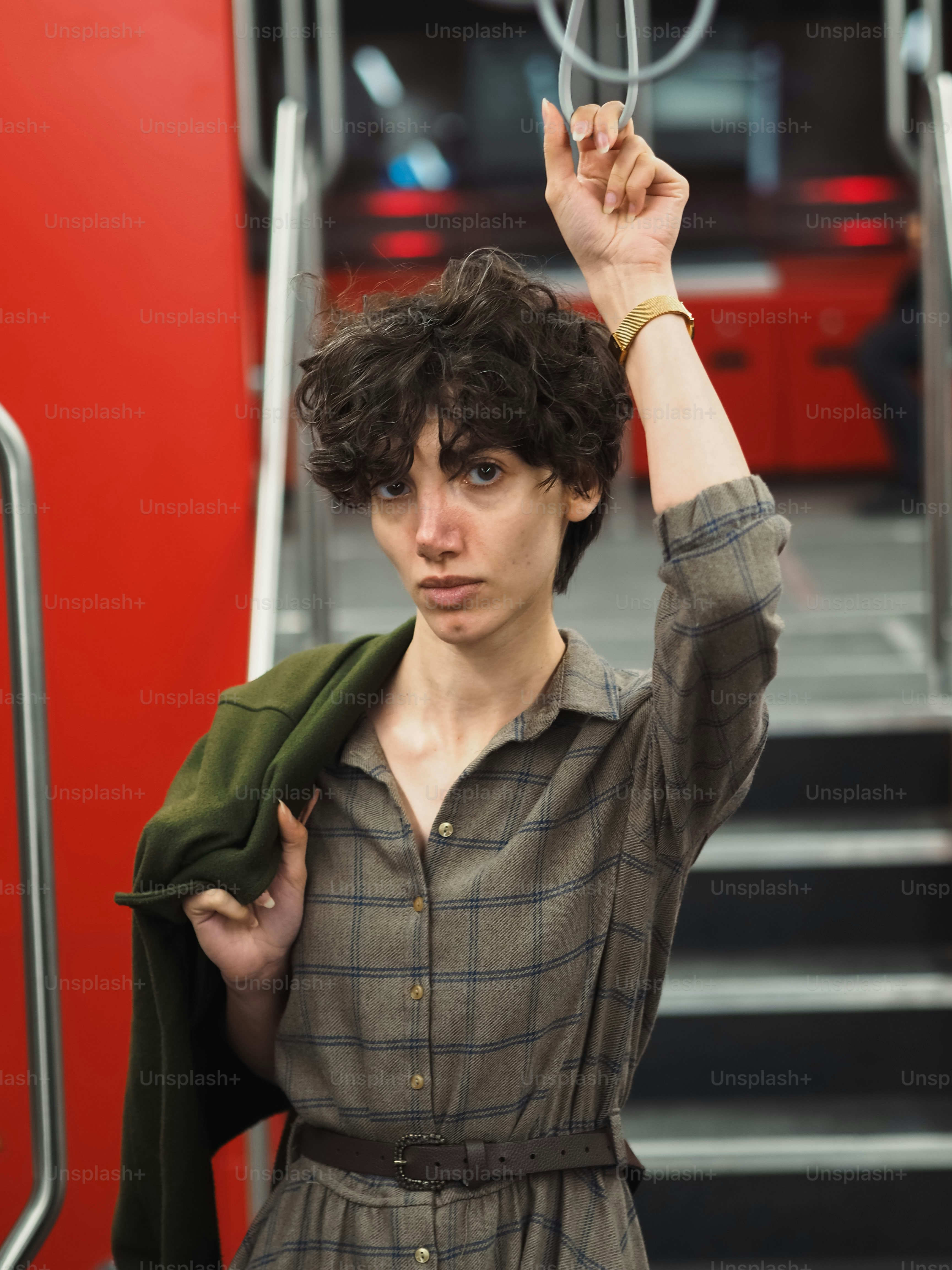 Una mujer sosteniendo una chaqueta verde sobre su cabeza