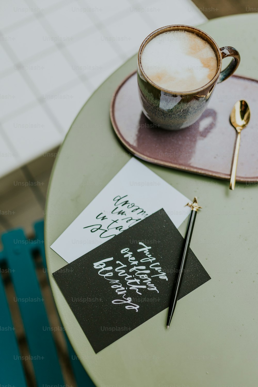 a cup of coffee sitting on top of a green table