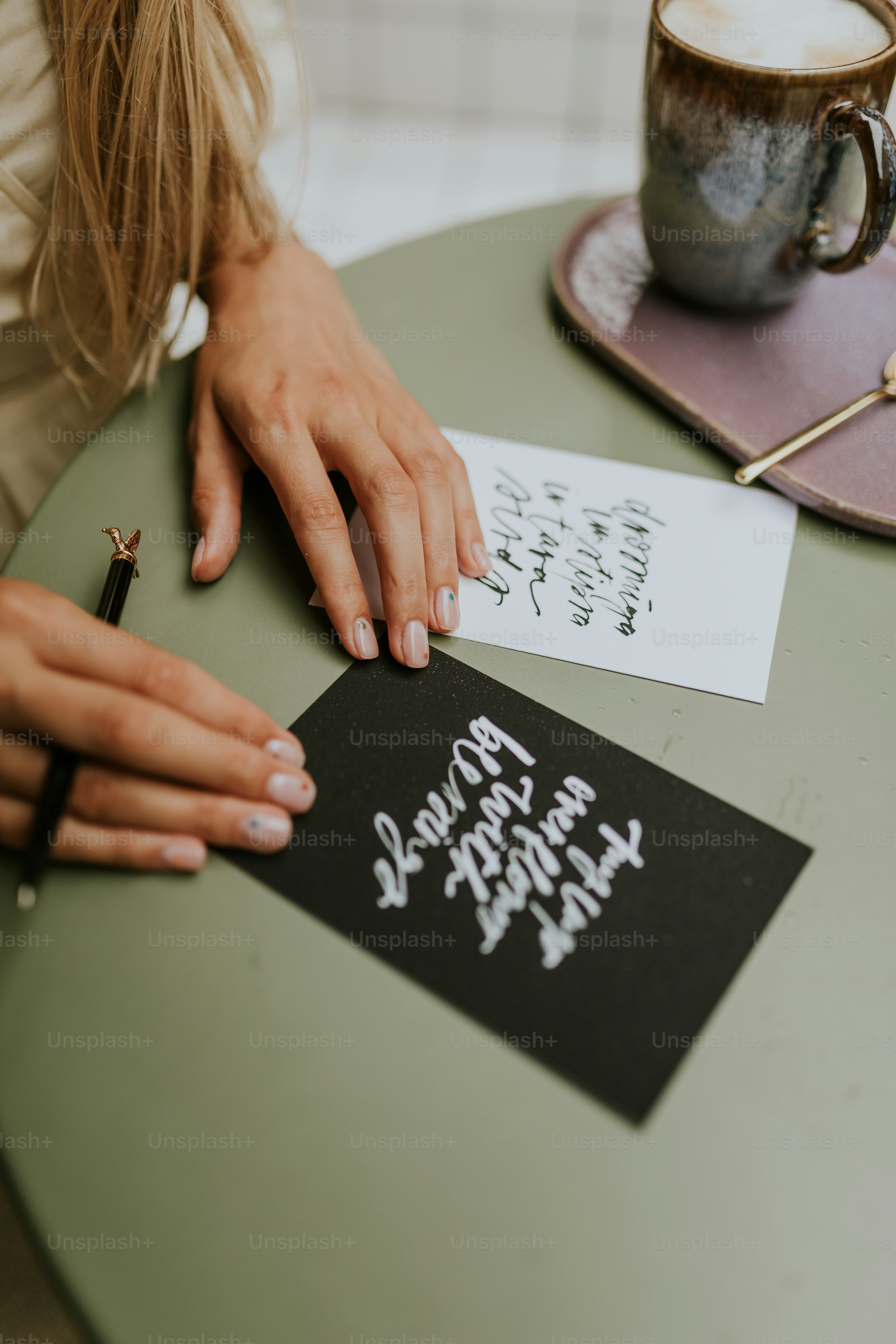 a woman writing on a piece of paper with a pen