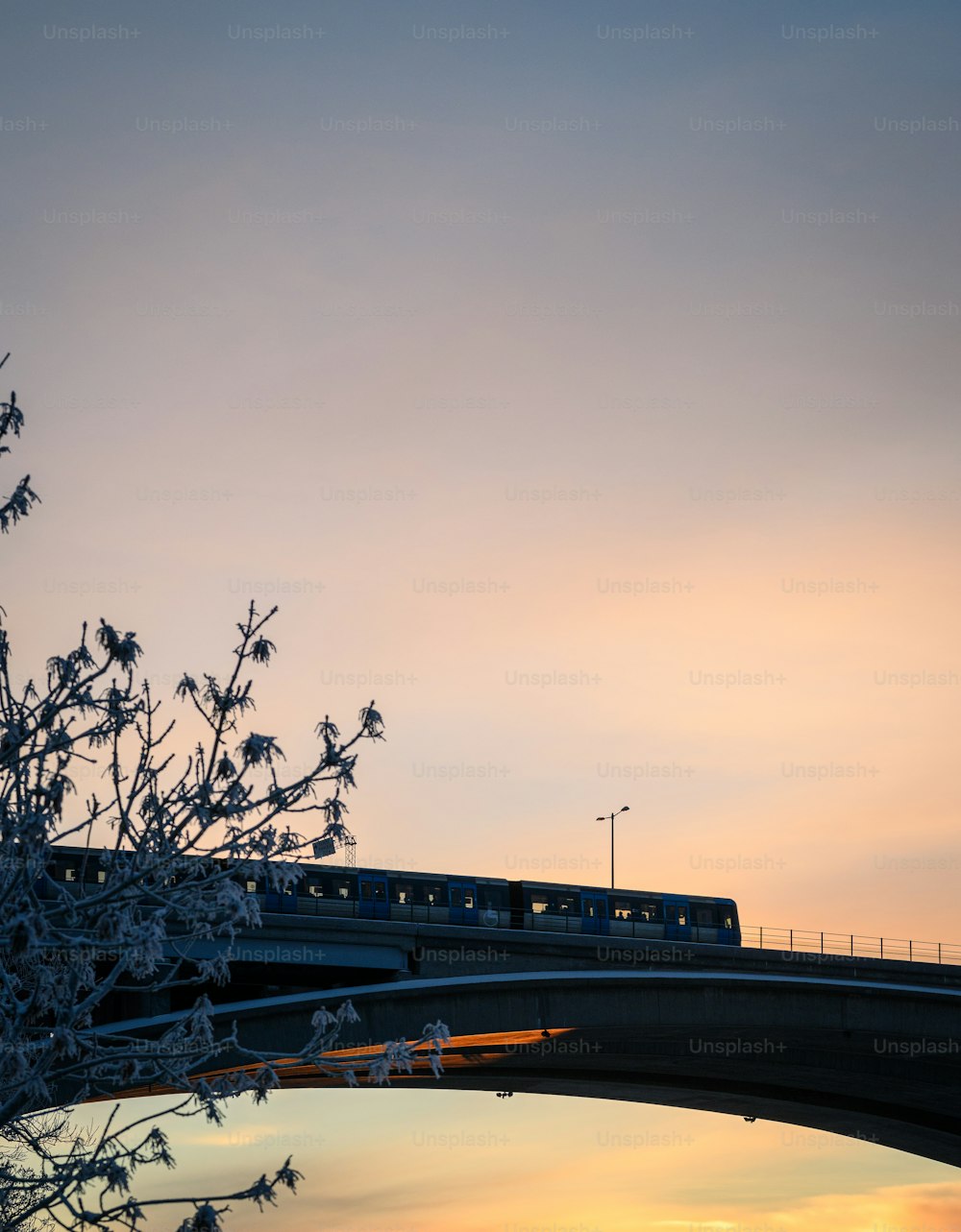 a train traveling over a bridge at sunset