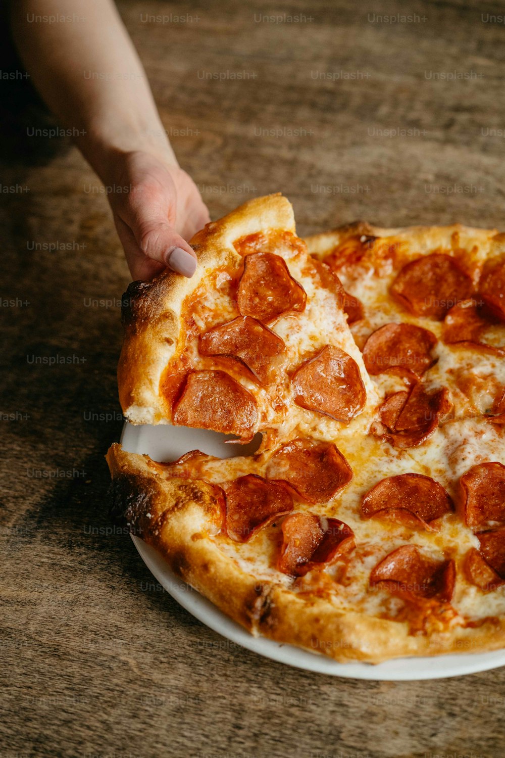 Une pizza au pepperoni sur une assiette blanche sur une table