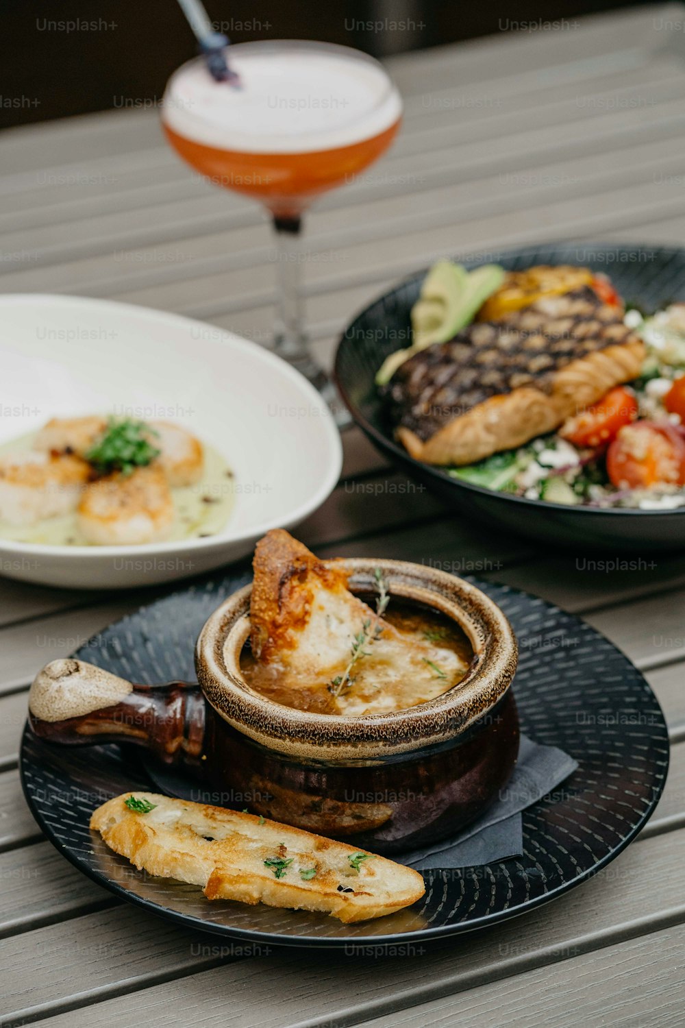 a table topped with plates of food and a wine glass