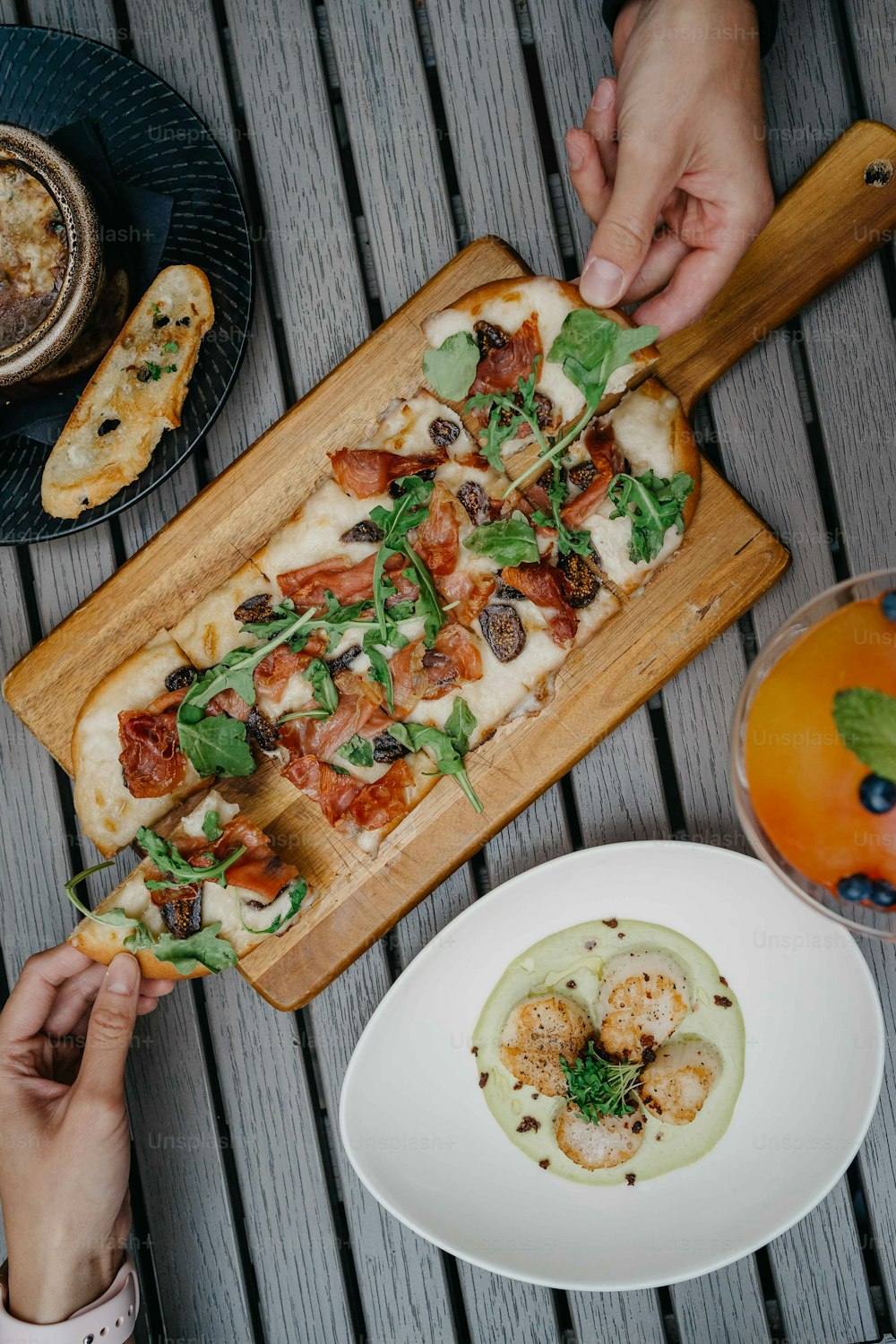 a person is cutting a pizza on a cutting board