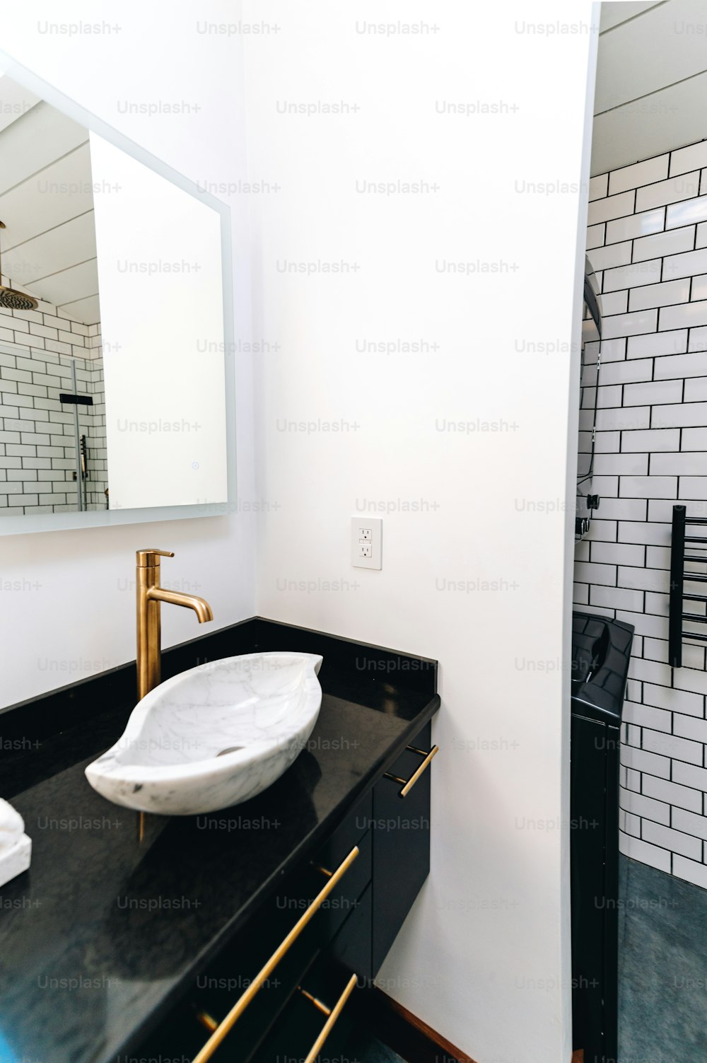 a bathroom with a black counter and a white sink