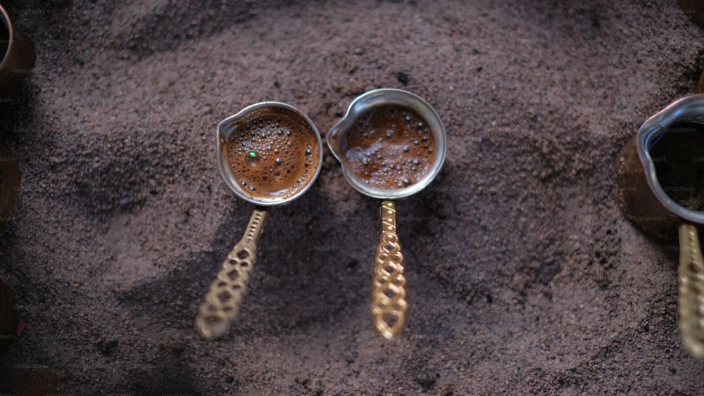 a couple of spoons that are sitting in the sand