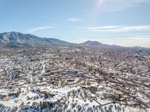 an aerial view of a city with mountains in the background