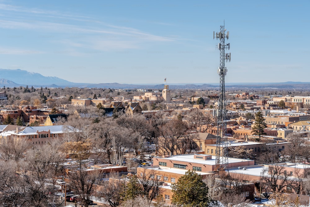 uma vista de uma cidade com uma torre de rádio em primeiro plano