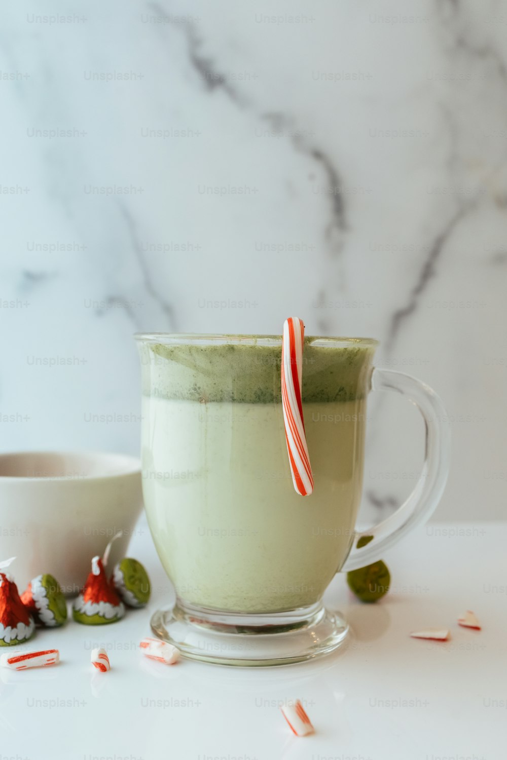 a cup of green tea with a candy cane sticking out of it