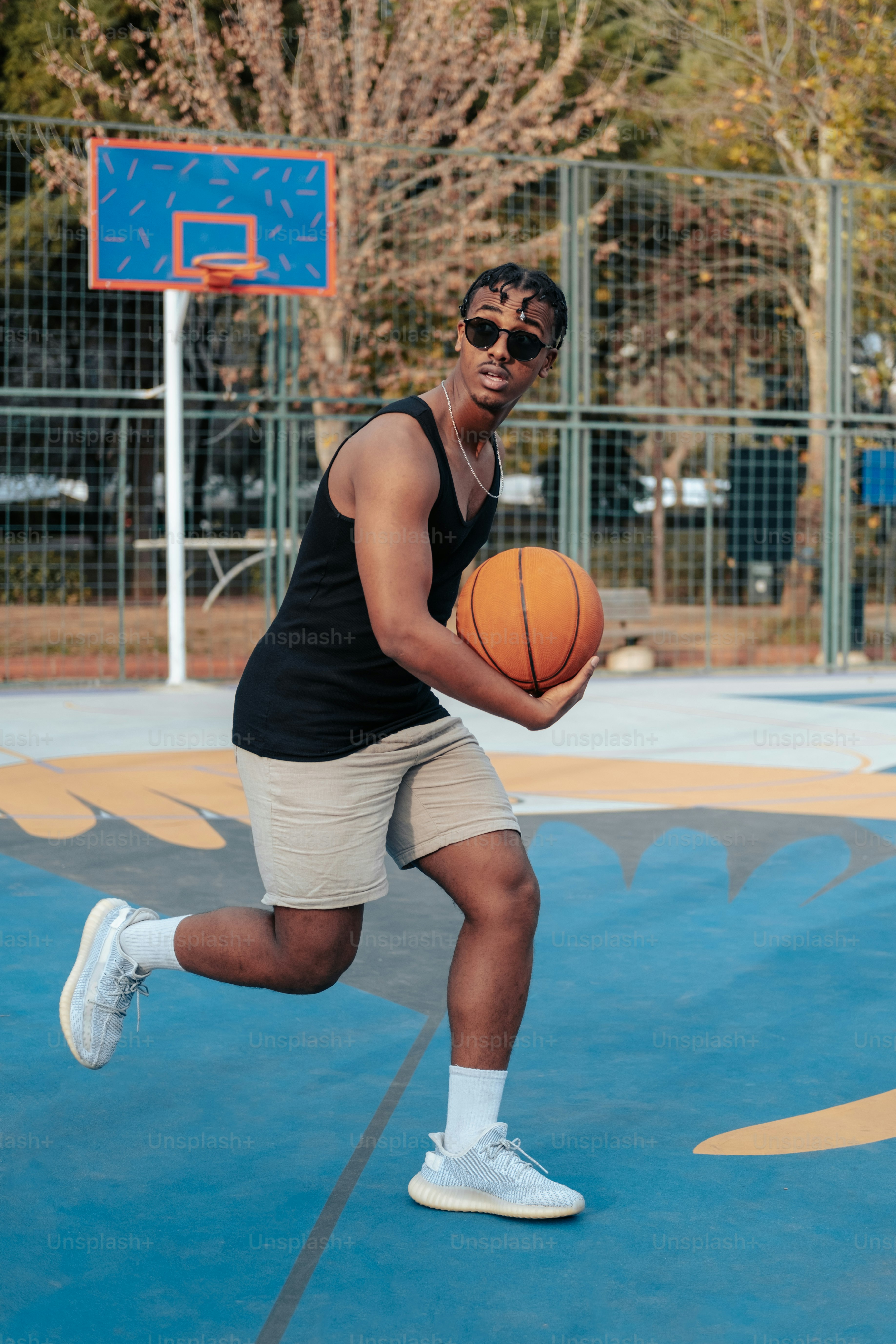 a man holding a basketball on a basketball court