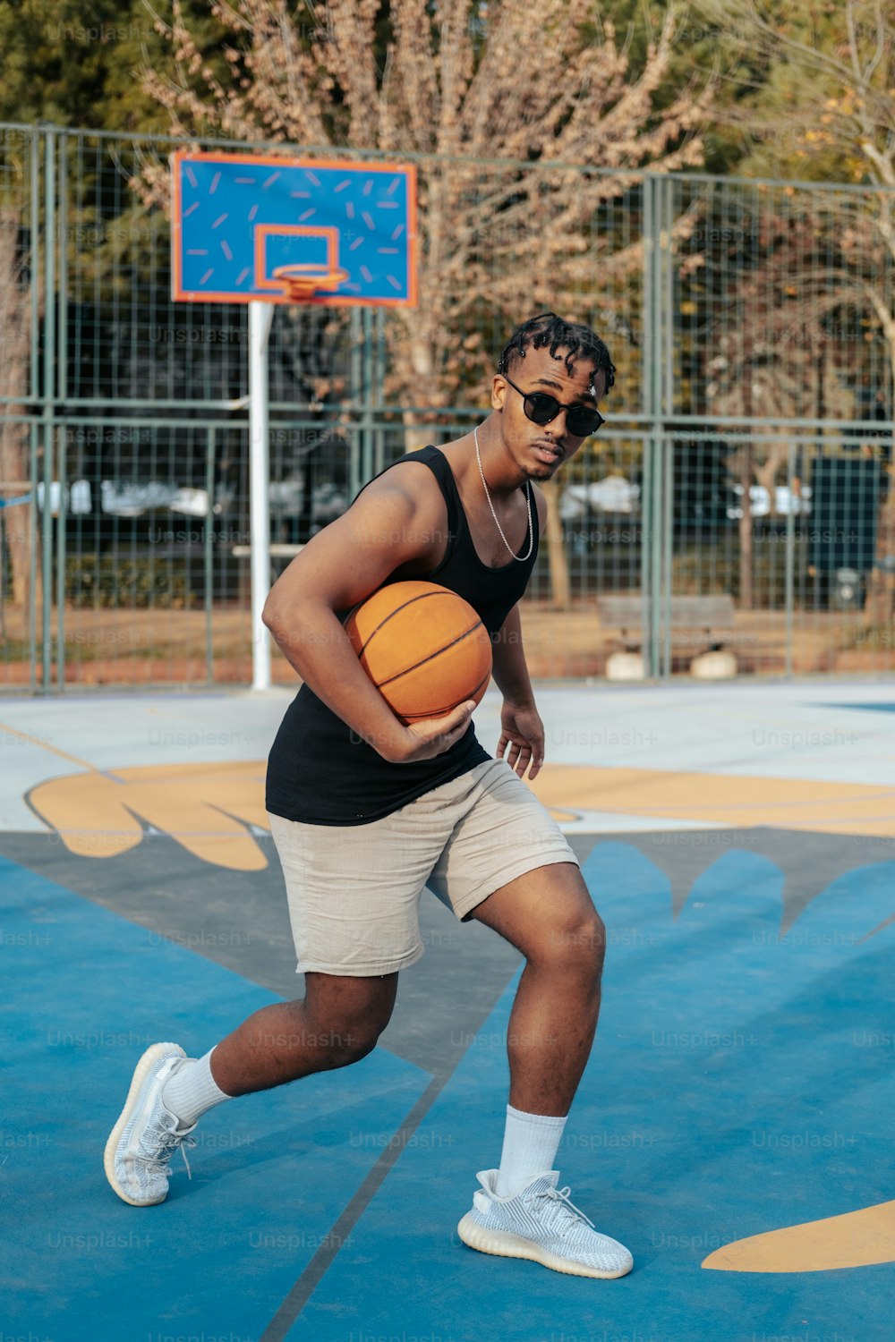 Un homme tenant un ballon de basket sur un terrain de basket-ball