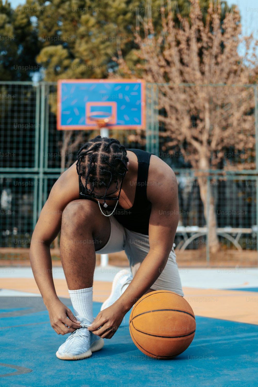 Un uomo con un pallone da basket su un campo