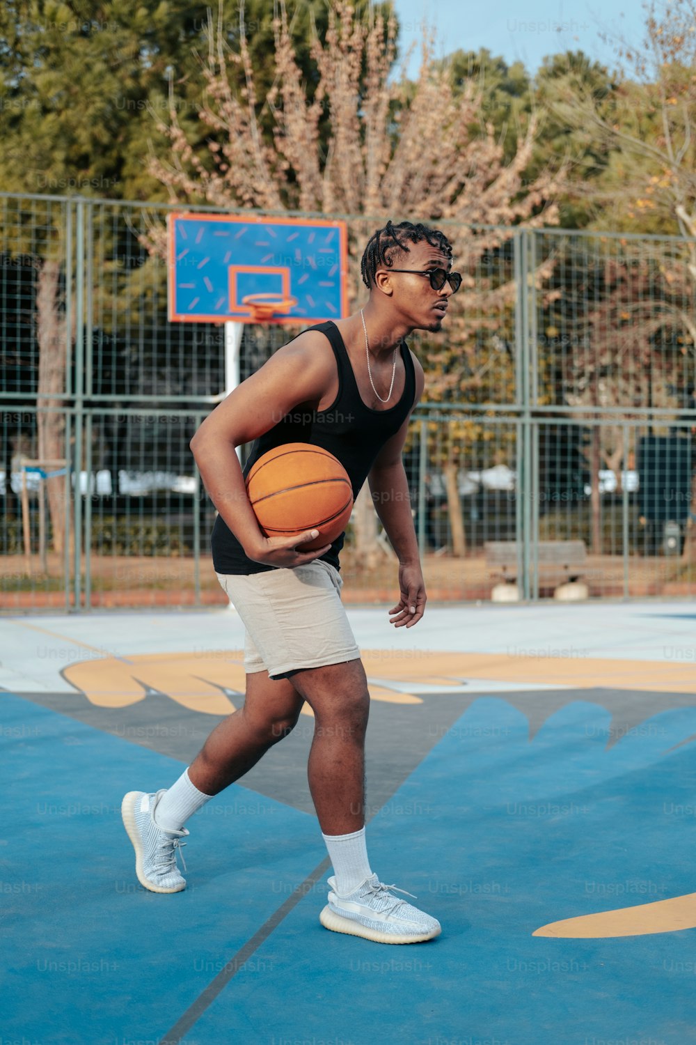 Ein Mann hält einen Basketball auf einem Basketballplatz