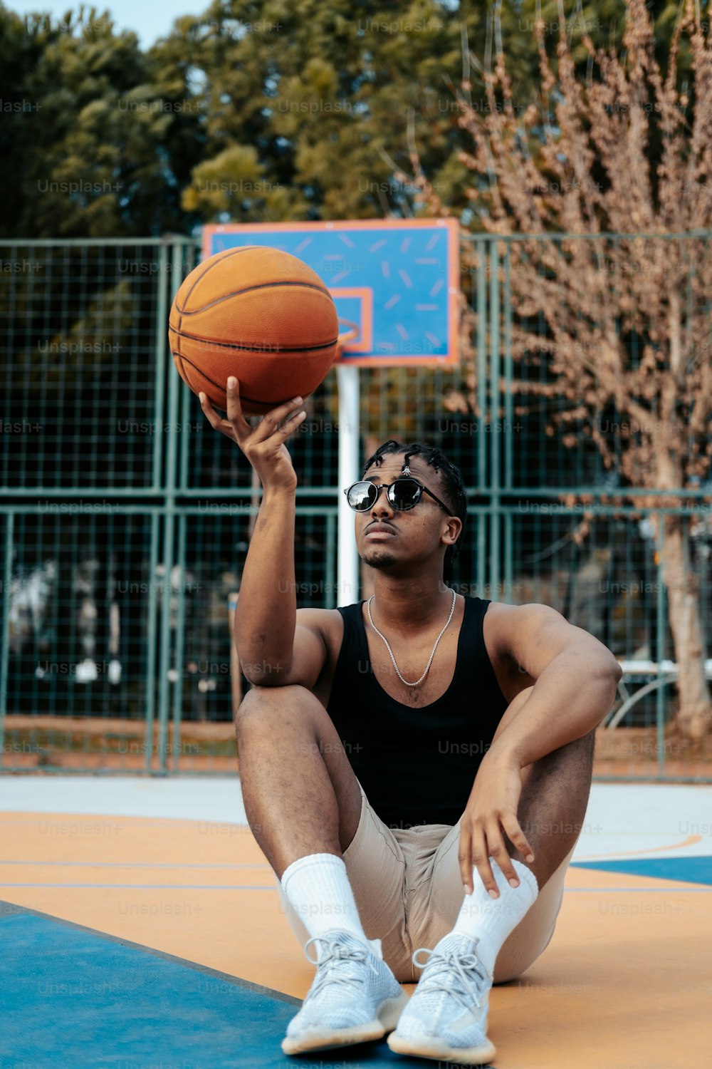 a man sitting on the ground holding a basketball