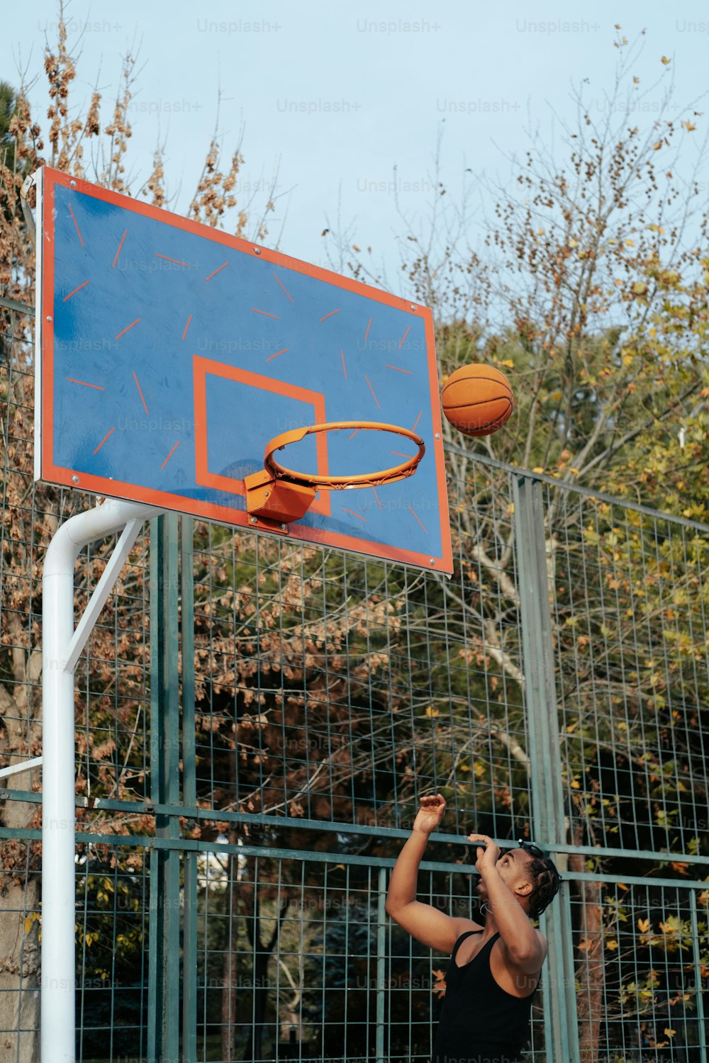 Un joven está jugando baloncesto en una cancha