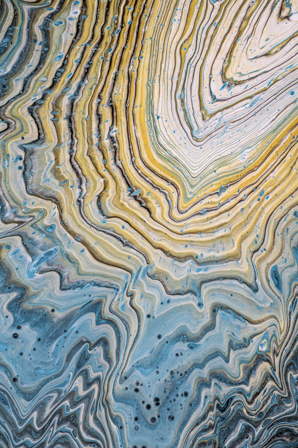 a close up view of a blue, yellow, and white marble