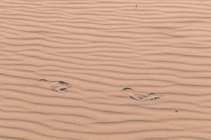 two footprints in the sand of a beach