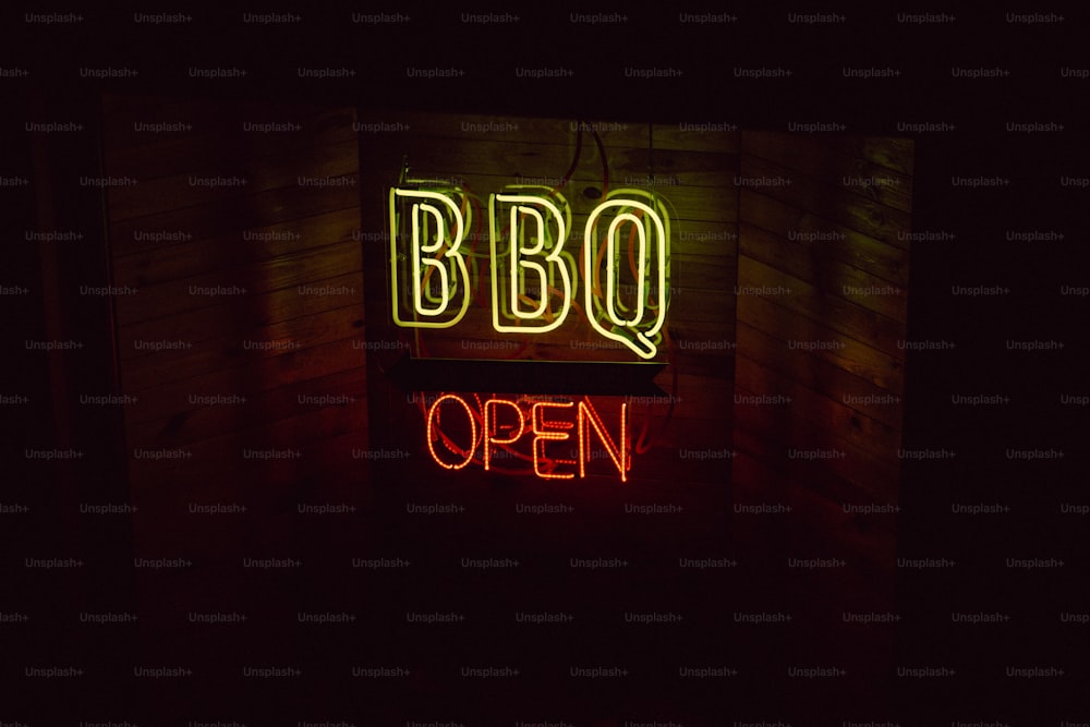 Un'insegna al neon che dice barbecue aperto in una stanza buia